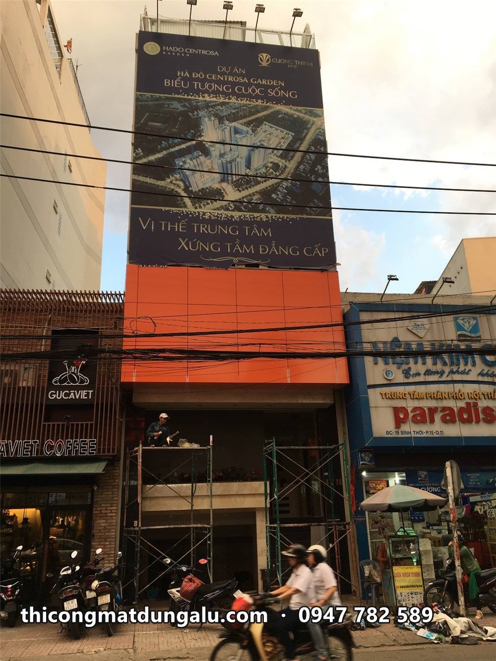 Mặt tiền văn phòng YesHouse đang thi công, mảng alu cam và pano phía trên