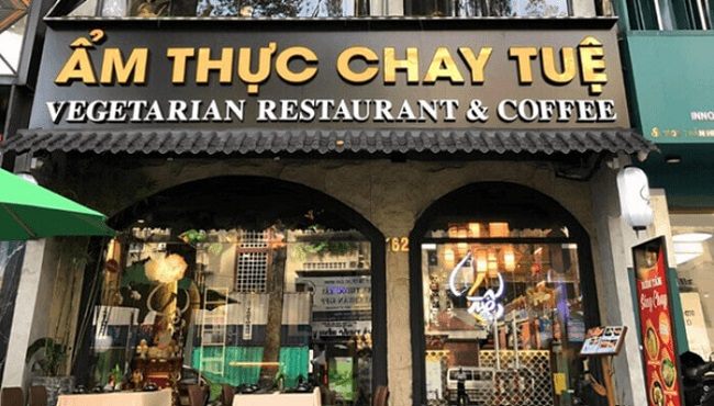 Nhà hàng chay mặt tiền vòm, chữ nổi vàng trên nền đen phía trên