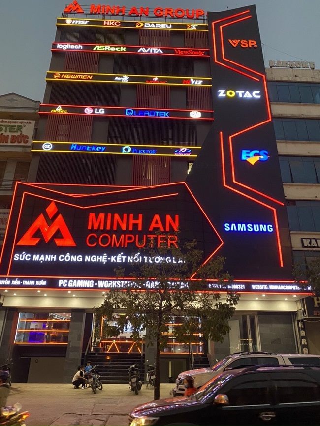 Tòa nhà cửa hàng máy tính với chữ và logo LED đỏ trên mặt dựng