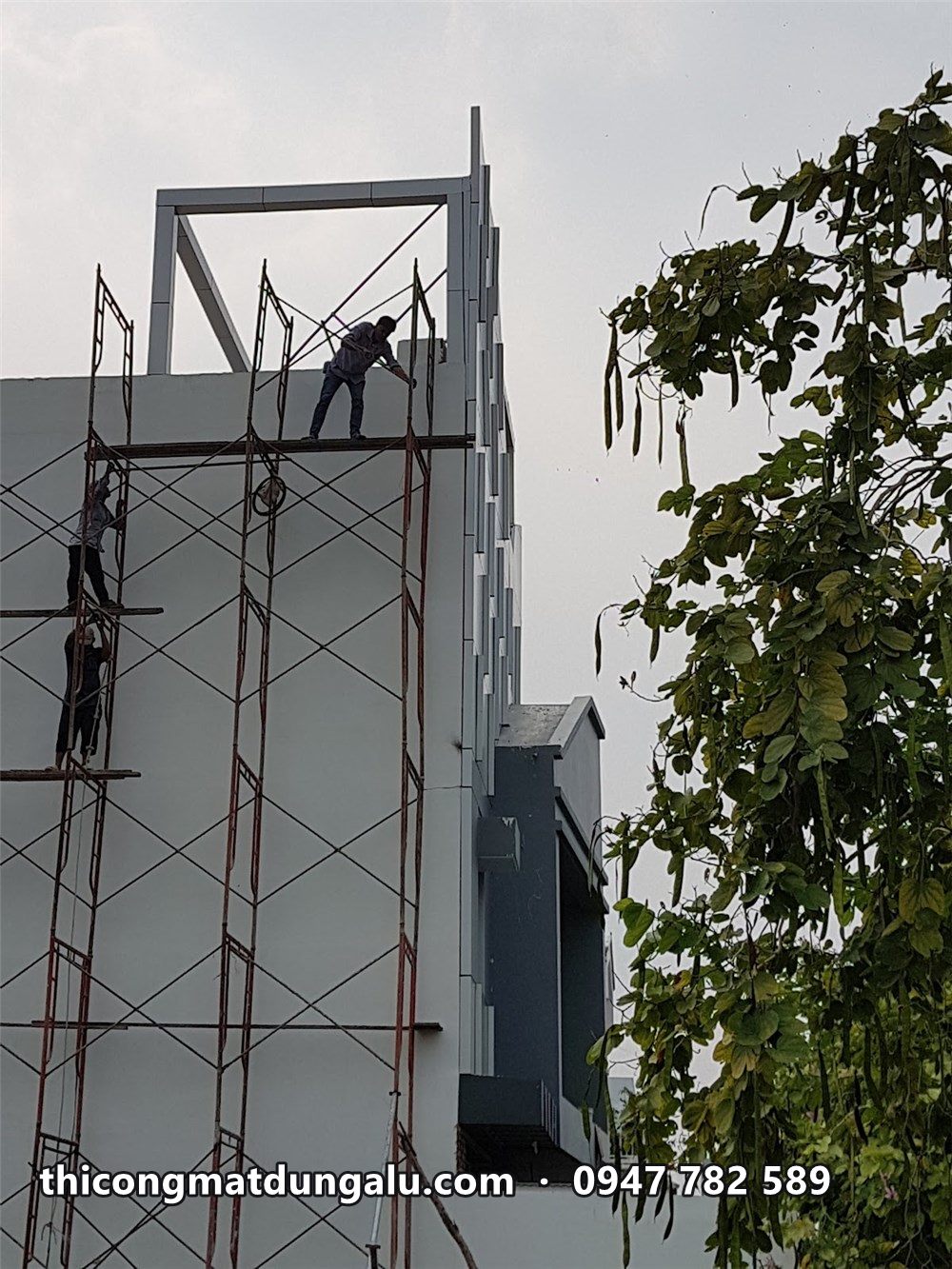 Thợ trên giàn giáo hoàn thiện khung đỉnh nhà phố