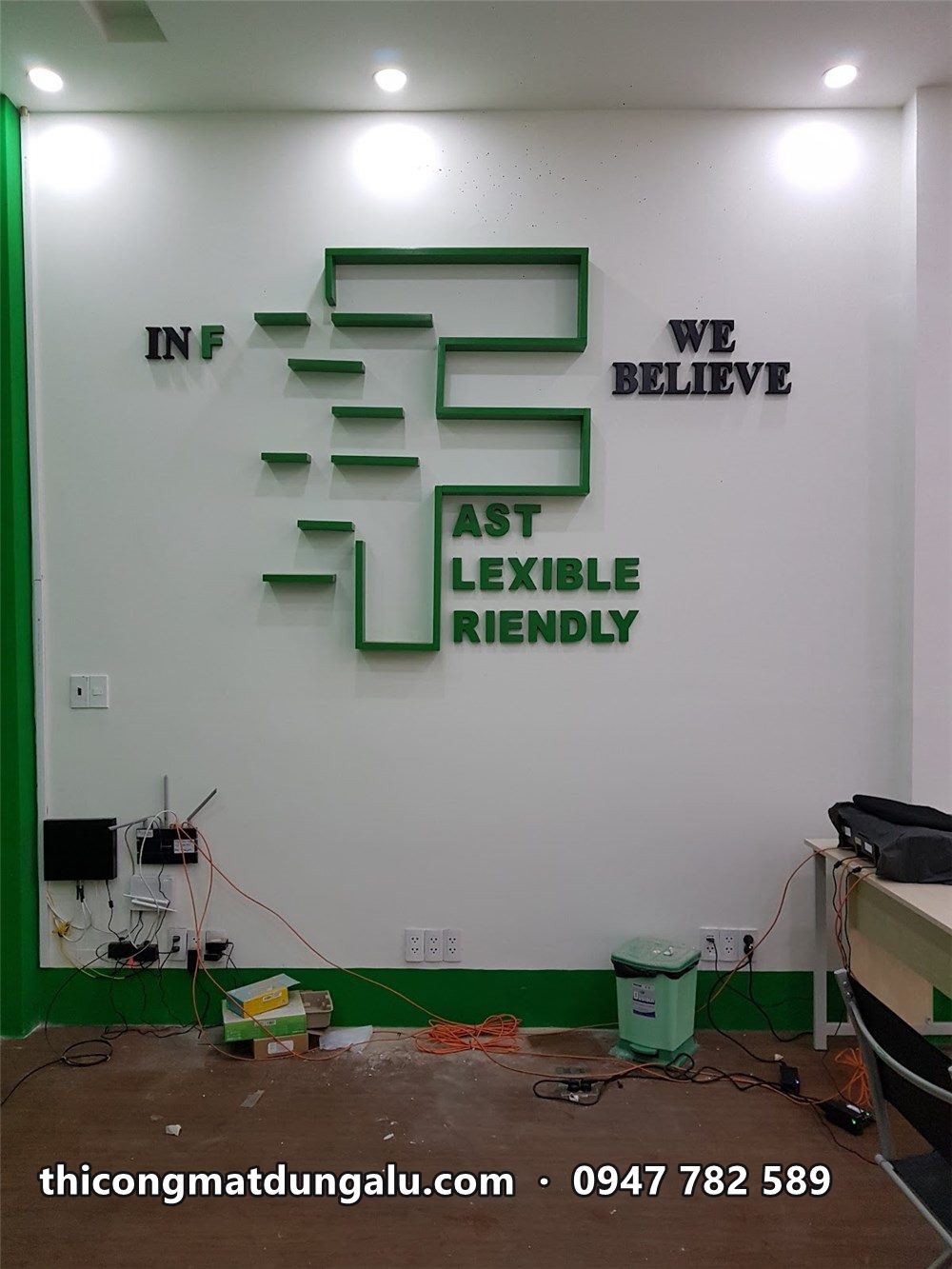 Chữ F xanh khổ lớn với Fast Flexible Friendly và We Believe trên tường trắng