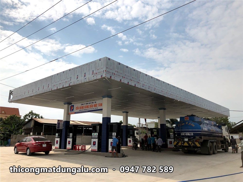 Mái che cửa hàng Petrolimex hoàn thiện, viền trắng và trần sáng, ô tô đổ xăng