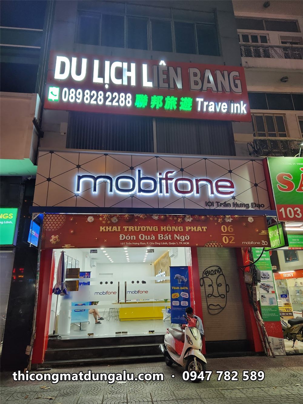 Tòa nhà Du lịch Liên Bang ban đêm với chữ nổi sáng và bảng Mobifone