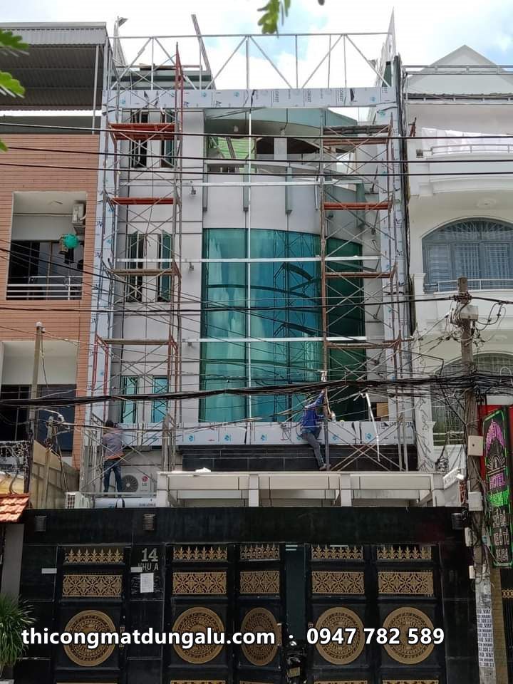 Nhà phố mặt kính xanh đang thi công, giàn giáo phía trước