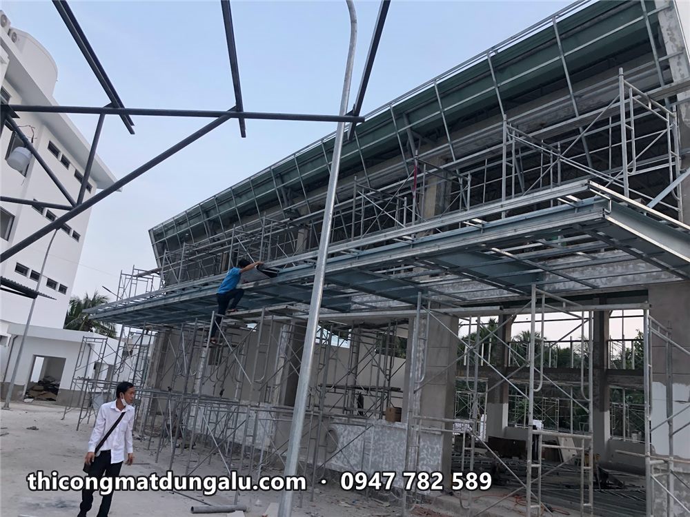 Khung thép mặt dựng và giàn giáo phía trước nhà thi đấu đang xây
