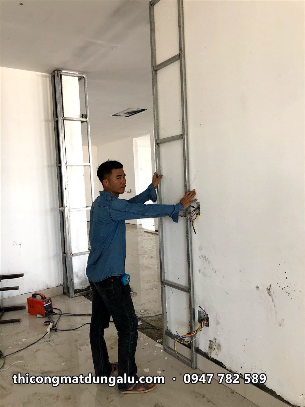 Thợ cân chỉnh khung xương cao sát trần trong showroom