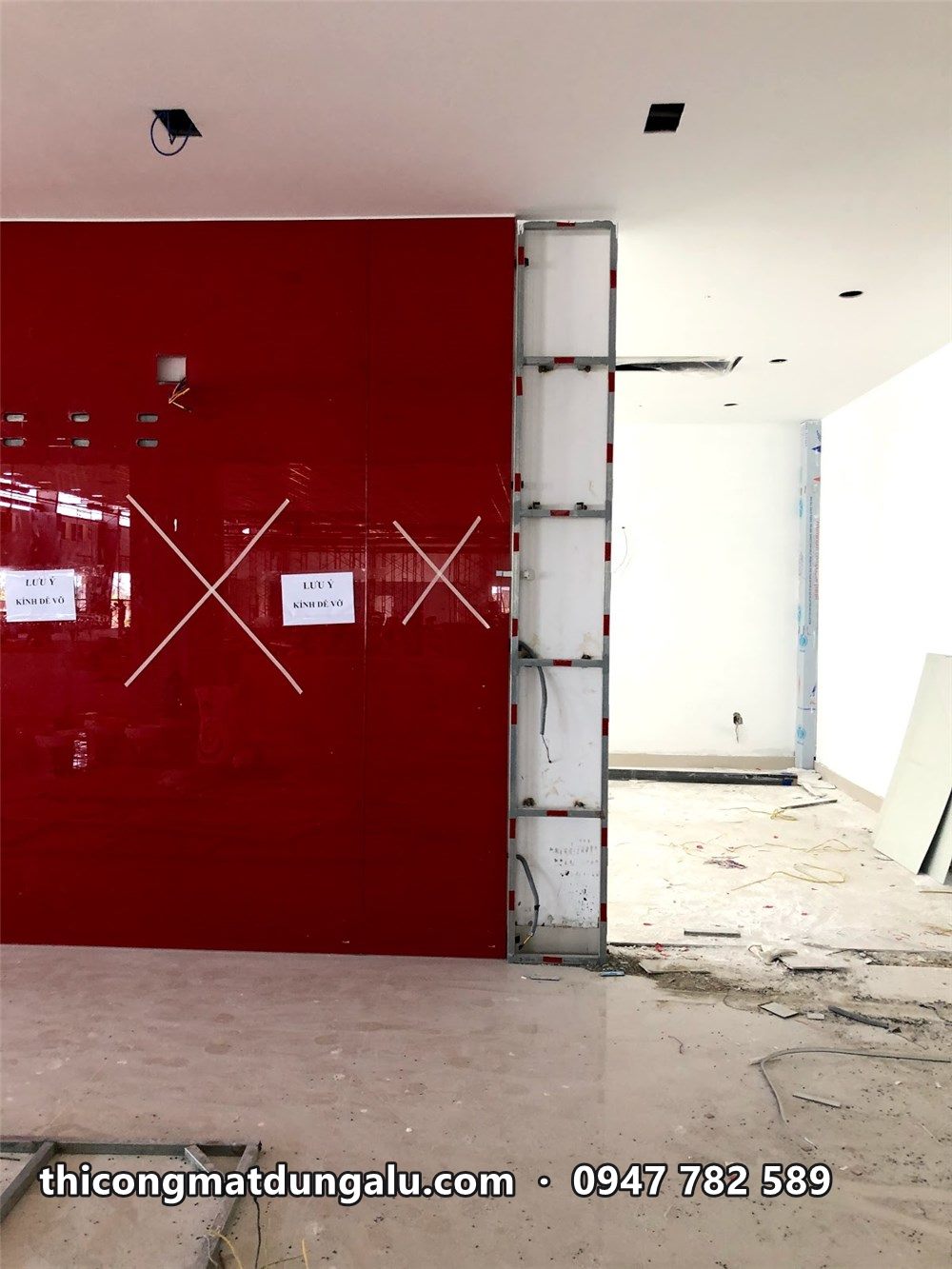Mảng tường alu đỏ bóng trong showroom, dán dấu X để nhắc tránh va chạm
