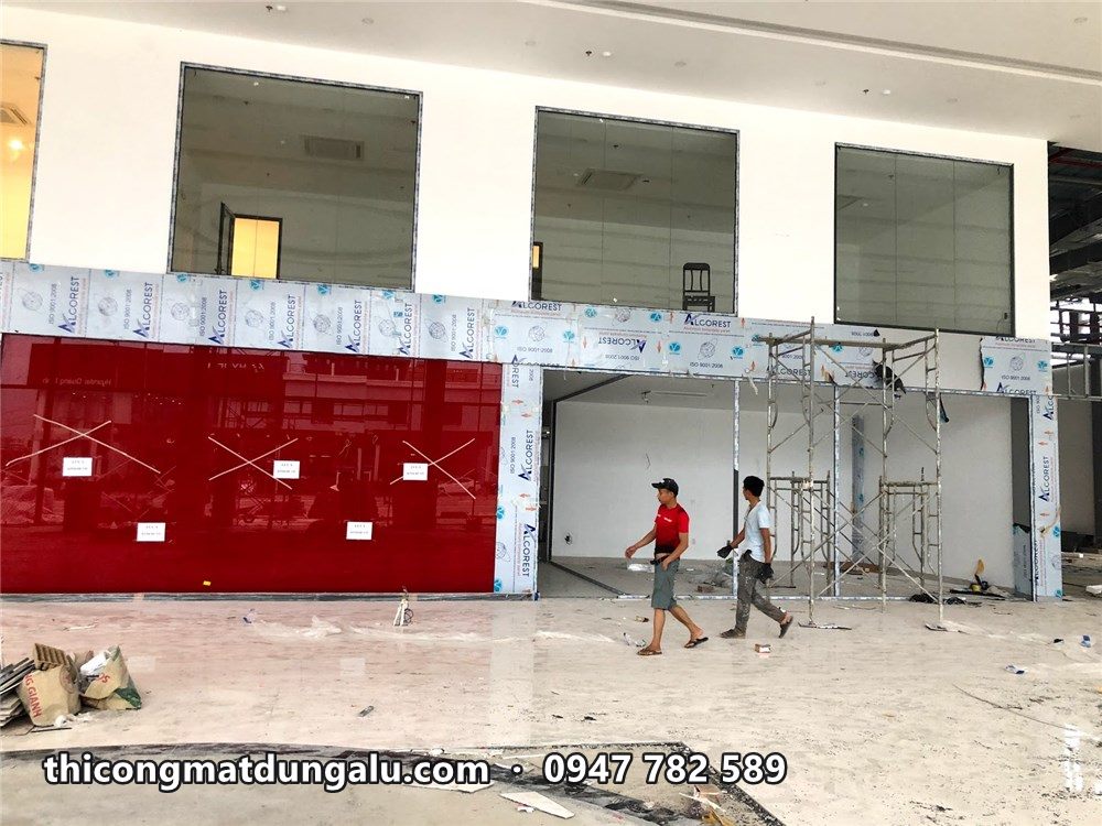 Dải tường alu đỏ dài trong sảnh showroom, phía trên là ô kính tầng lửng
