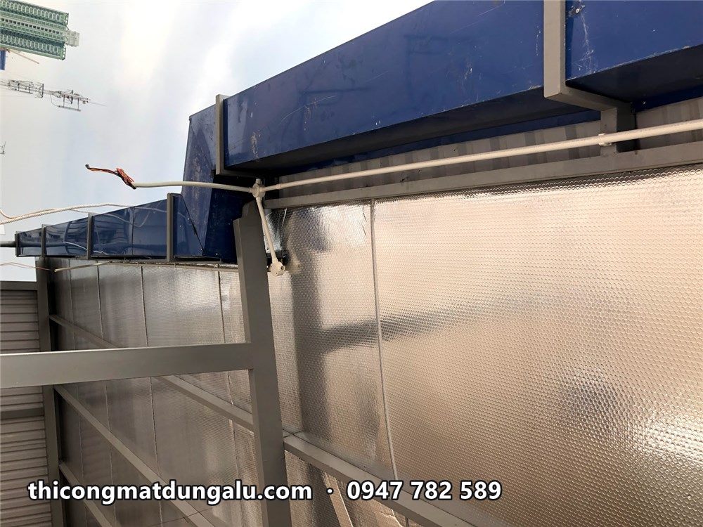 Viền alu xanh trên mép mái che nối với tường nhà xưởng
