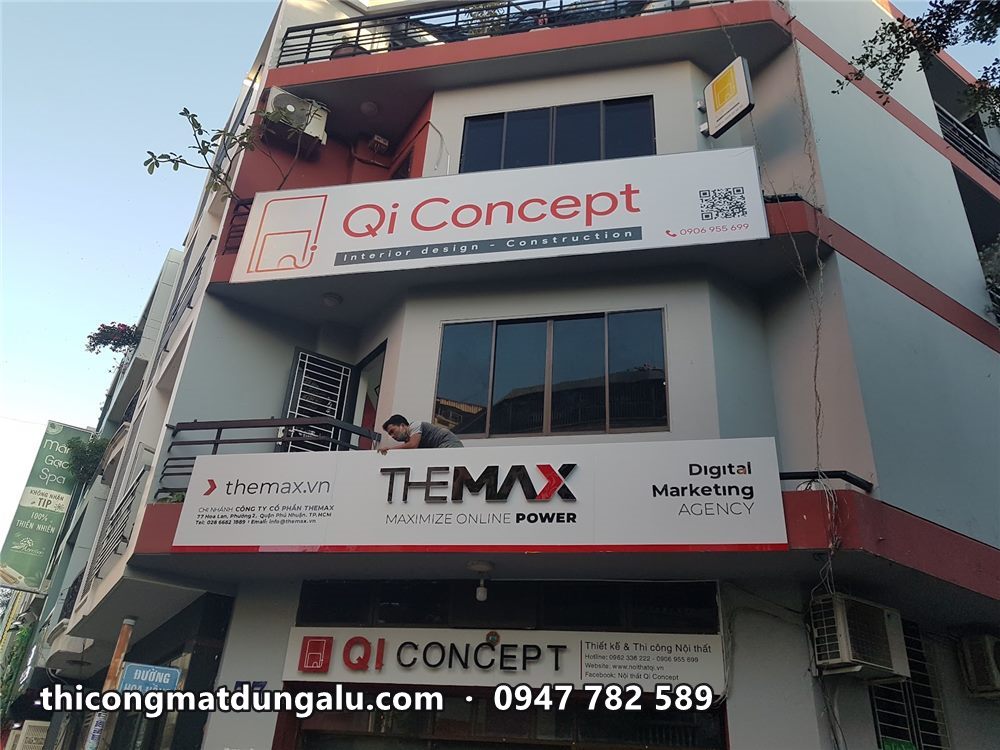 Tòa nhà góc đường với bảng Qi Concept và Themax trên các tầng