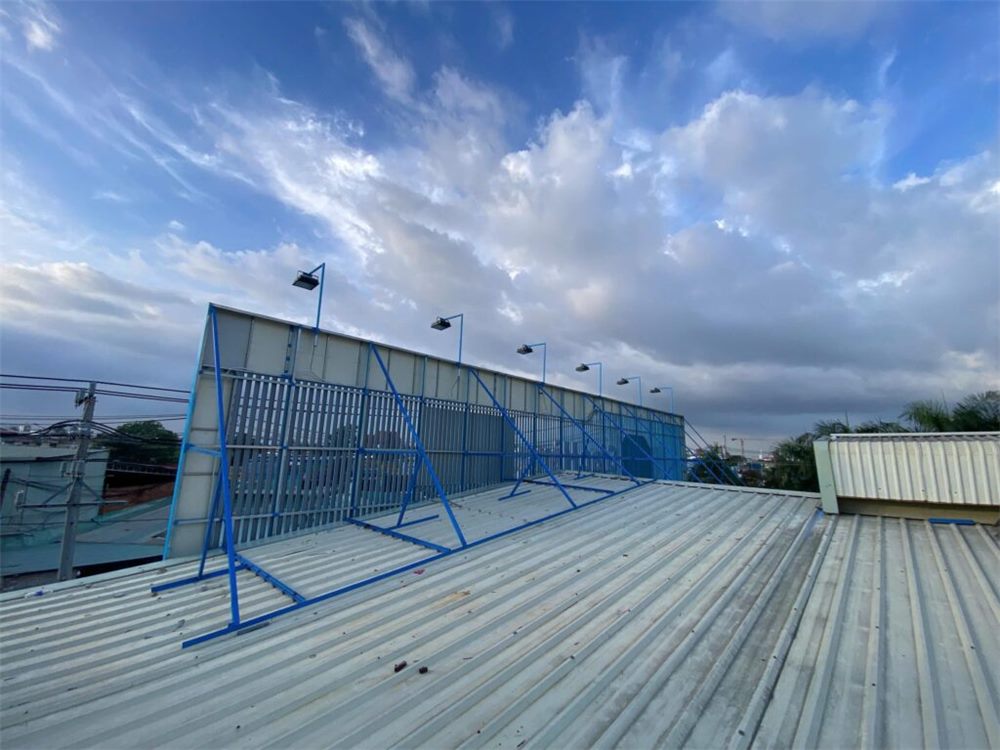 Khung thép pano dựng trên mái tôn nhà xưởng với hệ giằng chéo và đèn chiếu