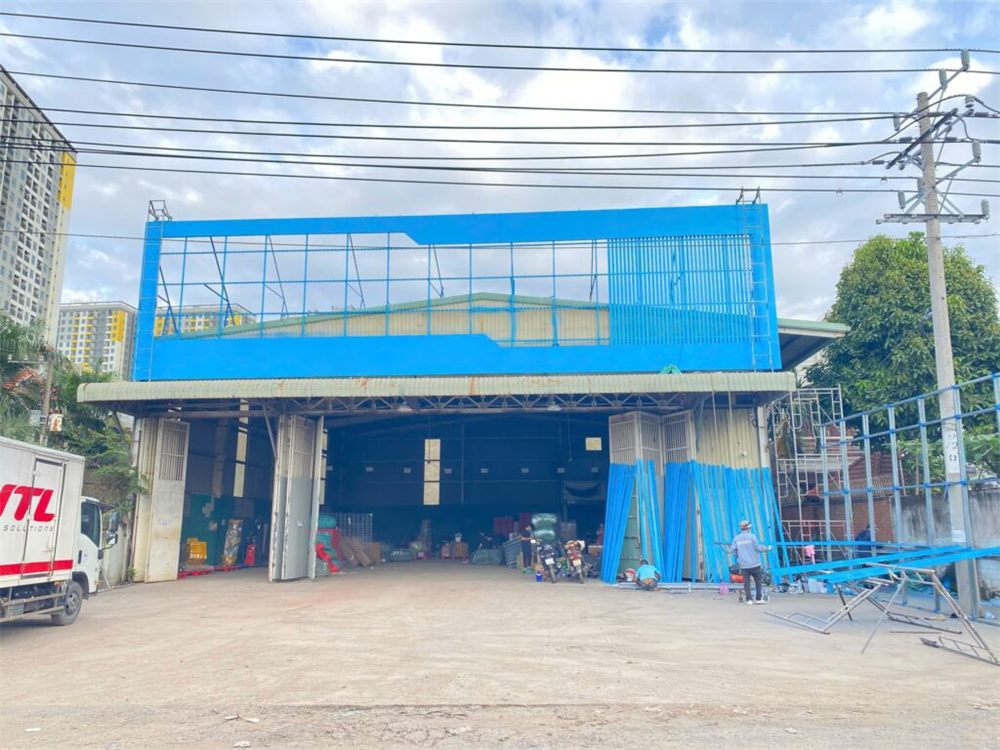 Mặt tiền nhà kho với khung pano xanh đã lắp gần xong phía trên mái