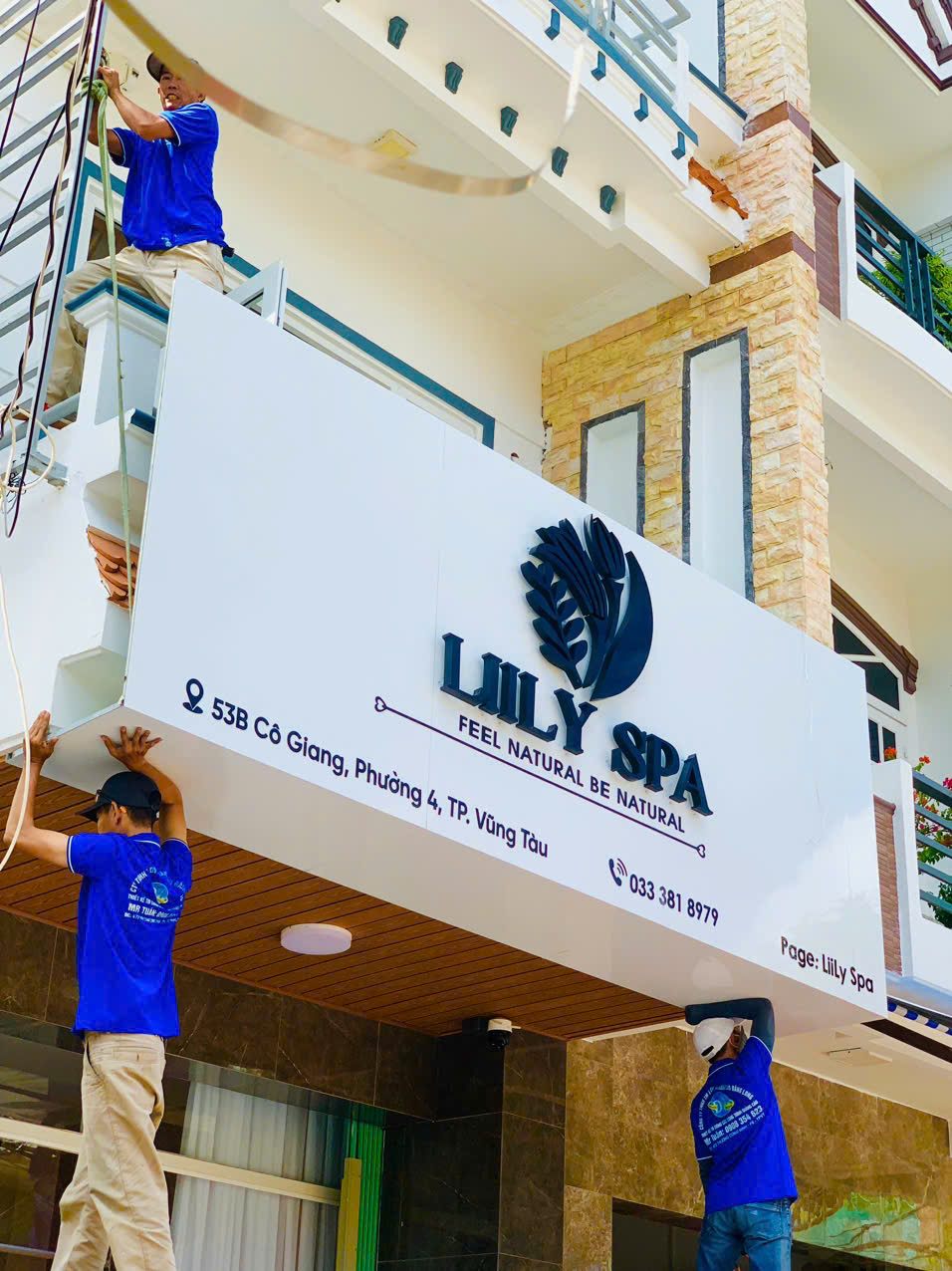 Thợ lắp tấm bảng hiệu spa có logo và chữ nổi lên mặt tiền