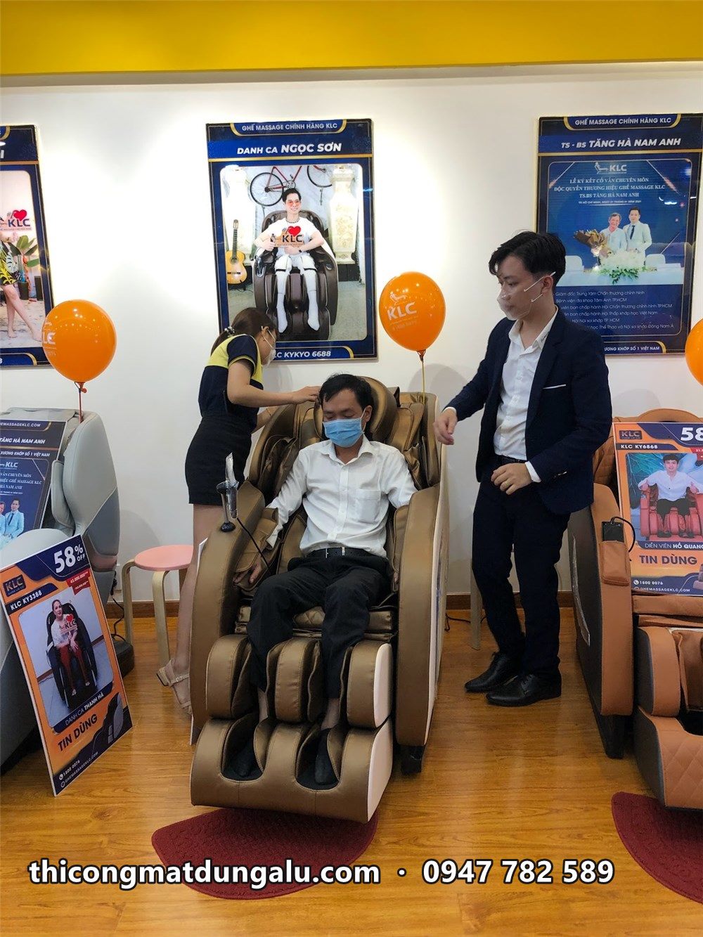 Khách ngồi thử ghế massage trong ngày khai trương, bóng bay cam trang trí