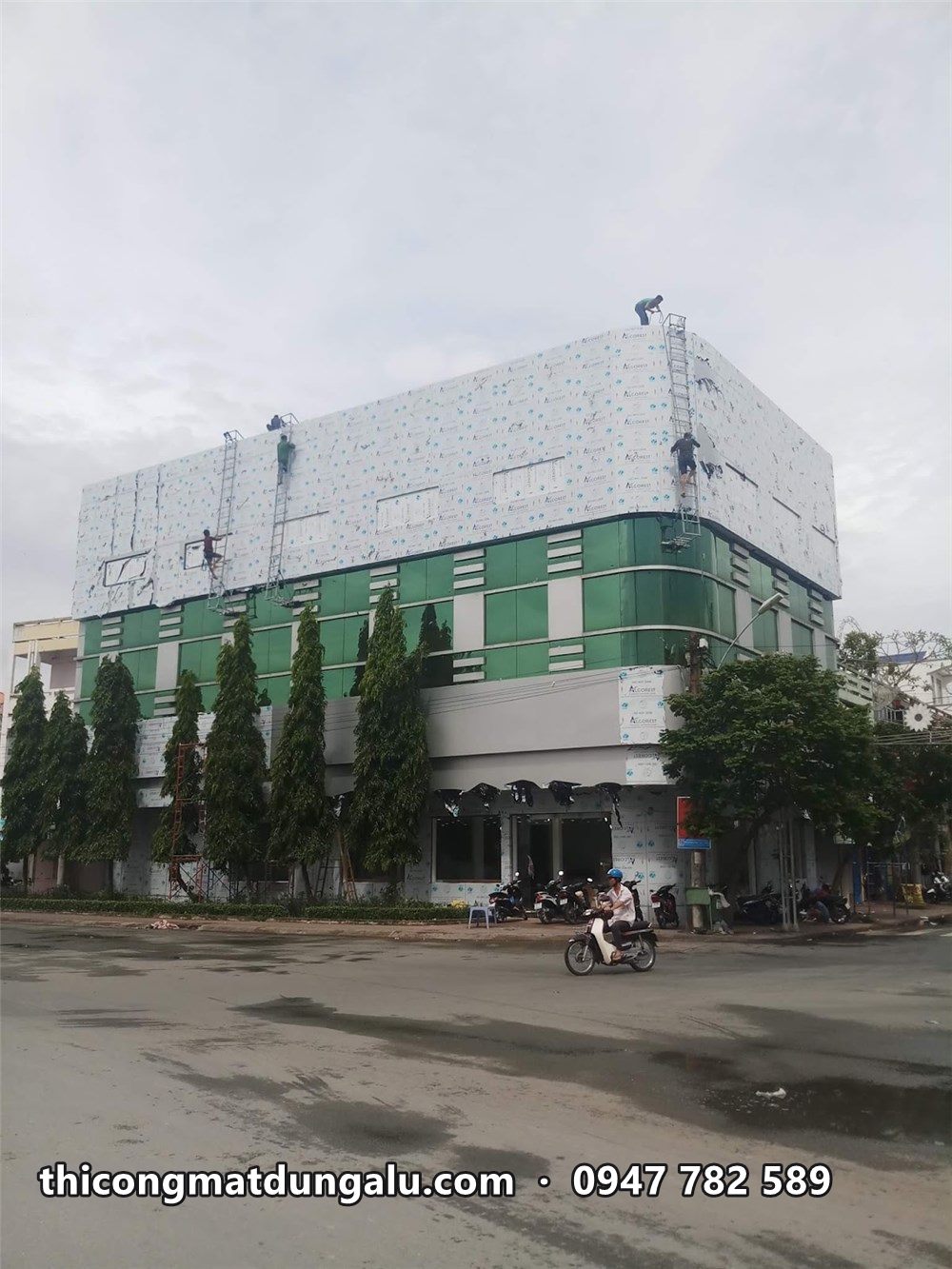 Thợ trên thang ốp alu tầng trên cùng showroom Phong Vũ