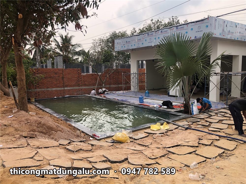 Viền mái ốp alu trắng còn màng nhìn từ sân, hồ bơi và cây cọ phía trước