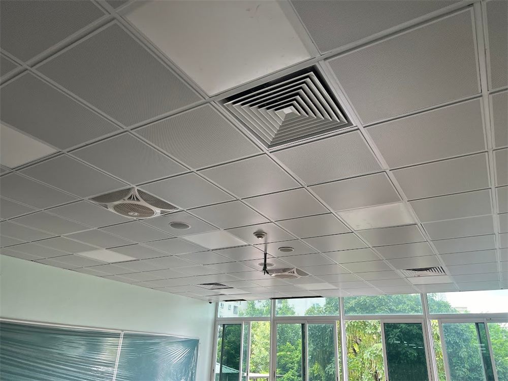 Trần nhôm thả trắng đã hoàn thiện trong phòng học với miệng gió điều hòa vuông