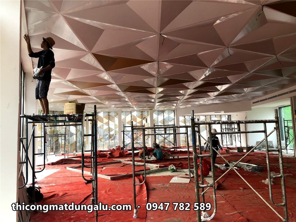 Thợ trên giàn giáo ghép tấm trần tam giác trắng, sàn phủ thảm đỏ bảo vệ