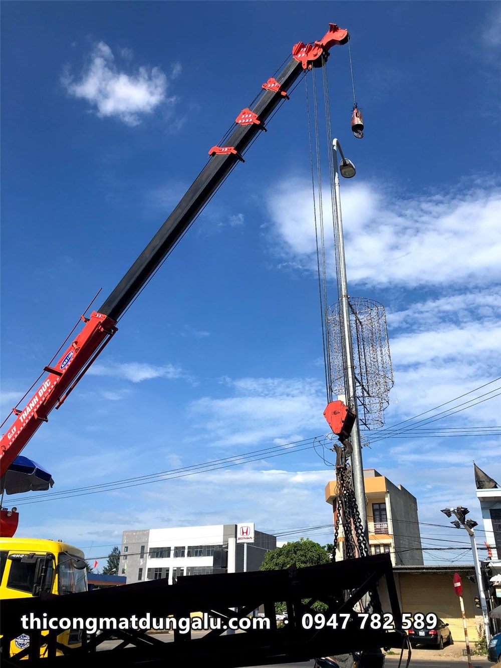Xe cẩu nâng khung chính thép V của trụ pylon lên vị trí, trời xanh