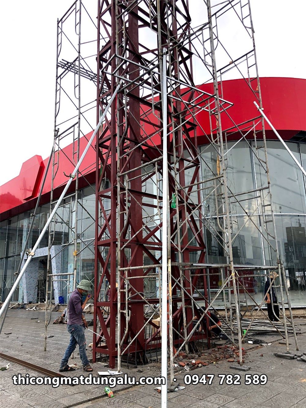 Giàn giáo bao quanh khung thép trụ pylon cạnh mặt tiền showroom