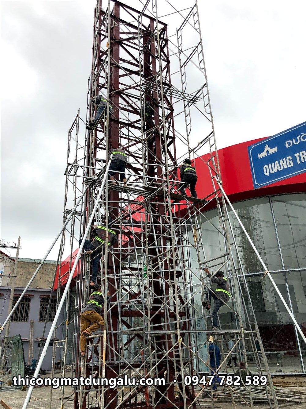 Thợ leo giàn giáo lắp khung xương ốp alu quanh khung chính trụ pylon