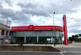 Ốp alu mặt dựng showroom VinFast Phúc Thành, Đồng Hới: mái cong đỏ và khối hộp trắng